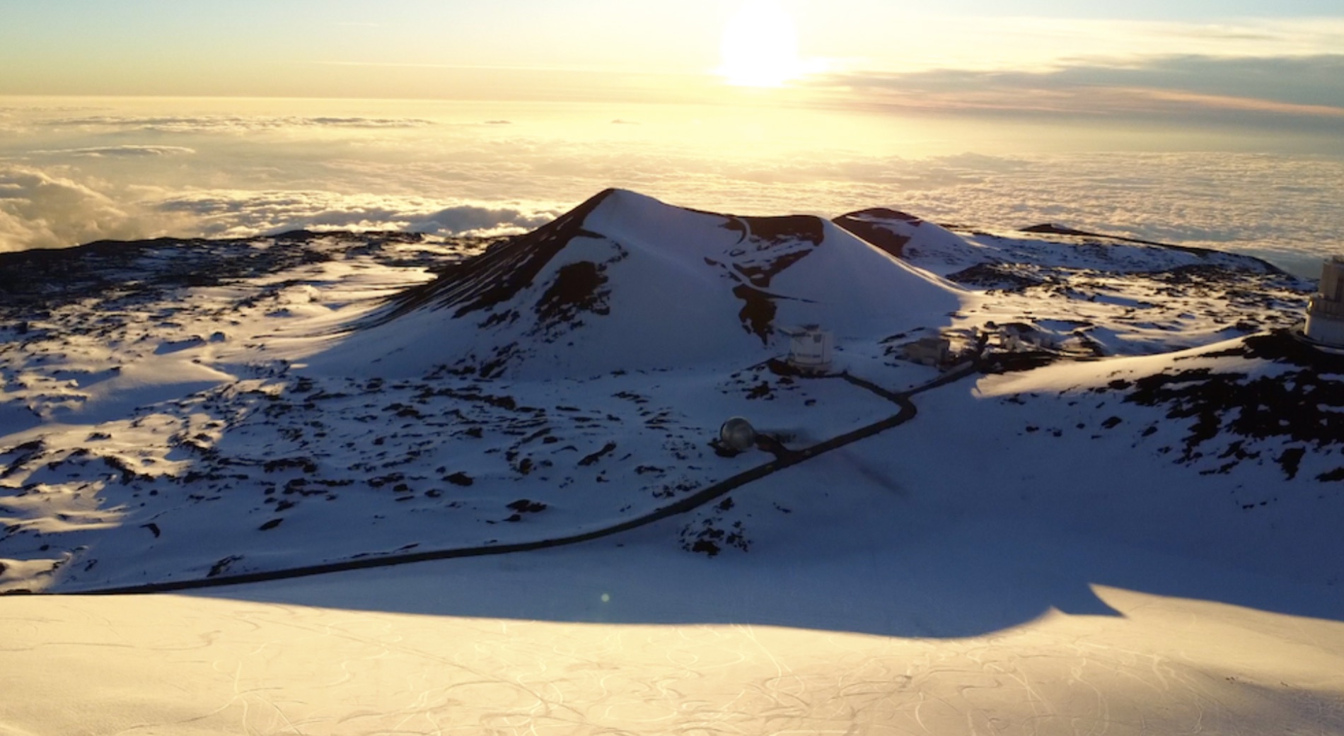 Snow on the summit of Mauna Kea above the cloud layer at sunset