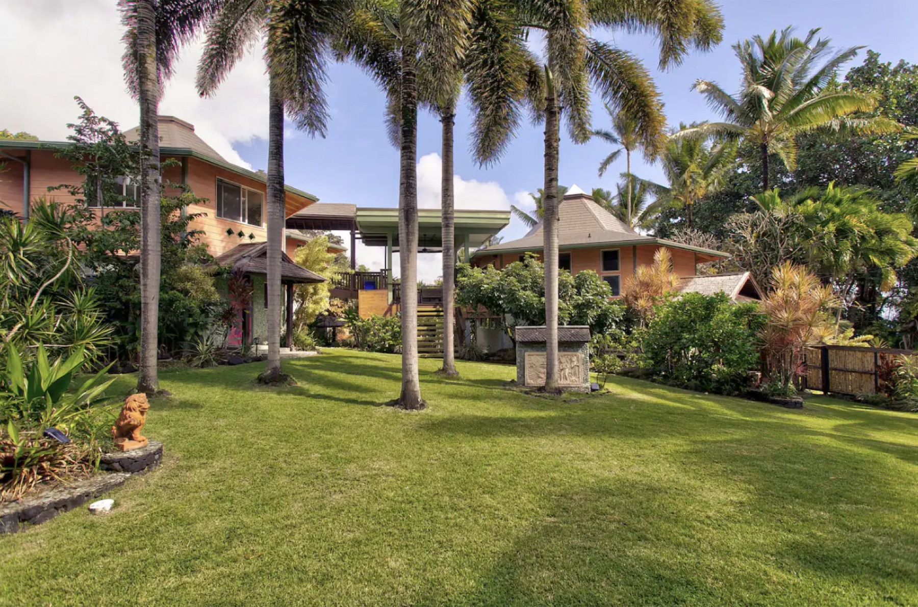 Palm-shaded lawn and cedar pavilions at the Pahoa retreat property