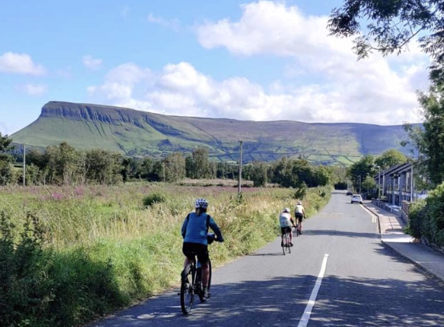 Cycling a quiet road below a table-top mountain in Sligo