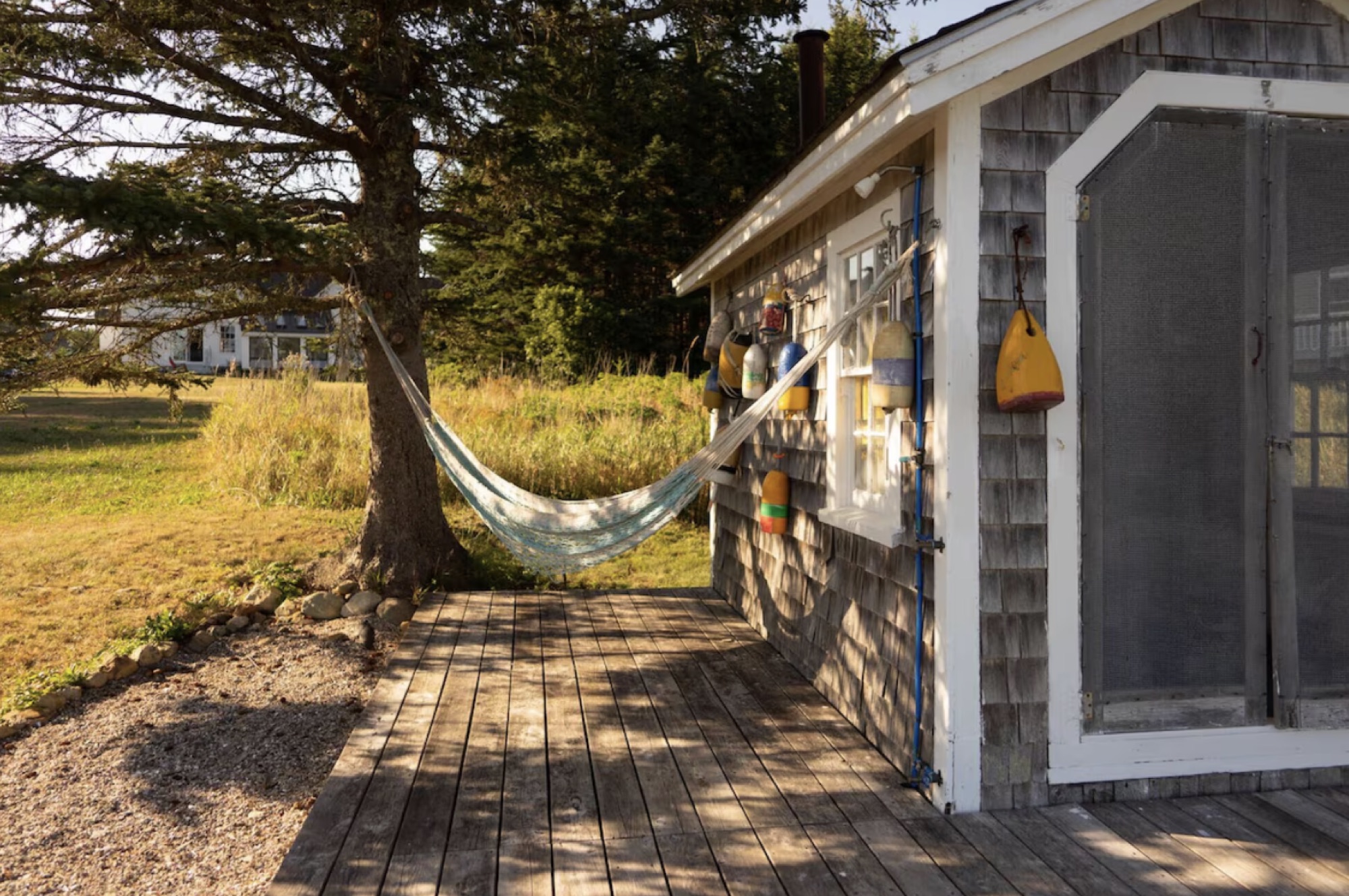 Cedar-shingled boathouse hung with lobster buoys, a hammock strung beside it