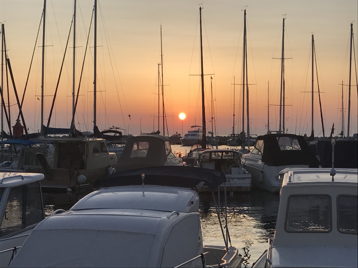 Sunset behind the masts of a marina on the Slovenian coast