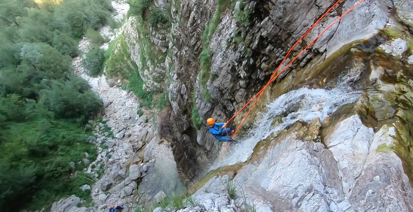 Canyoning guides on the rocks above an emerald pool in the Soča Valley