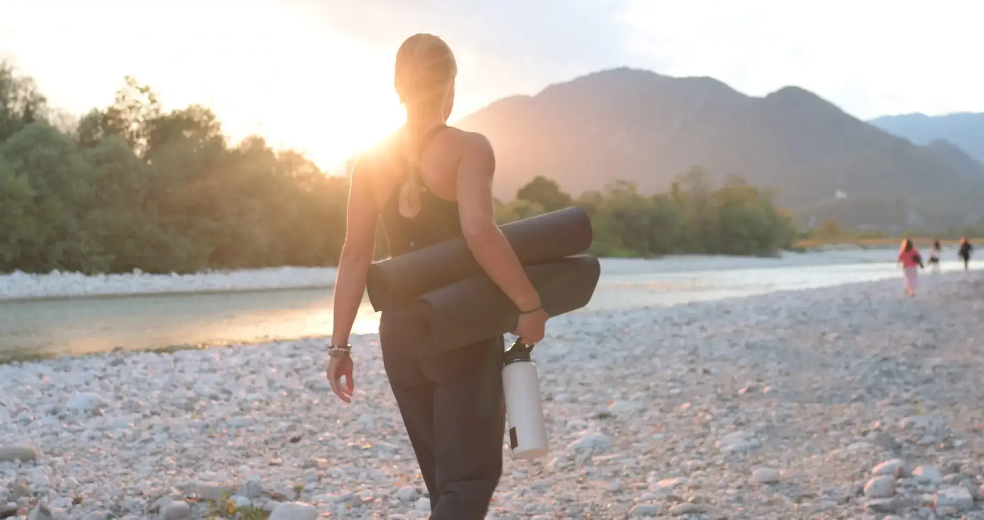 Walking back along the Soča riverbed with a yoga mat at sunset